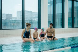 Famille citadine profitant d'une session de natation dans une piscine municipale couverte moderne en hiver