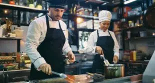 Two professional cooks working in the kitchen at restaurant.