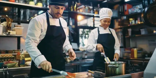 Two professional cooks working in the kitchen at restaurant.